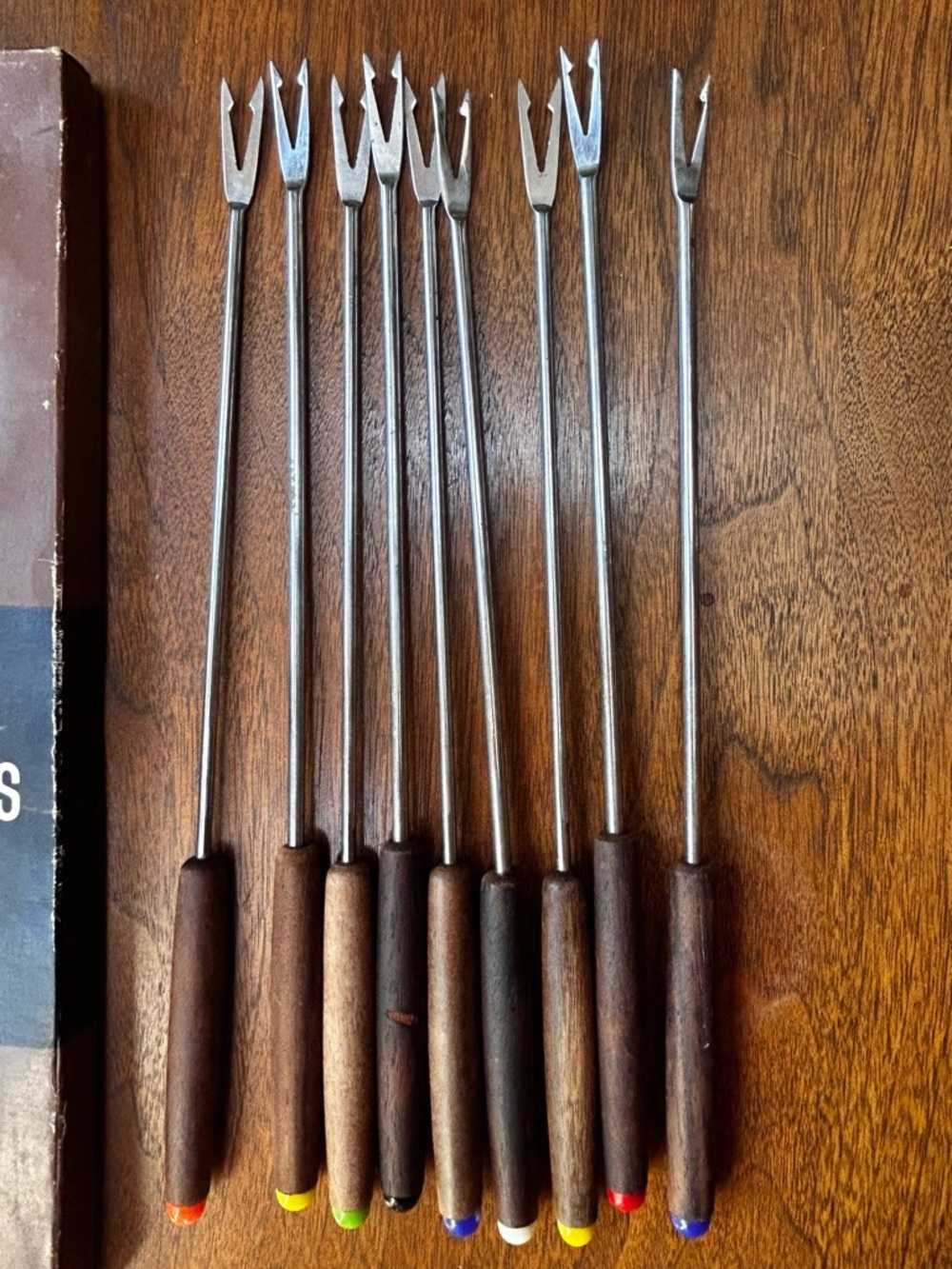 Nine vintage 1960s rosewood handled fondue forks with colored tips, by King.